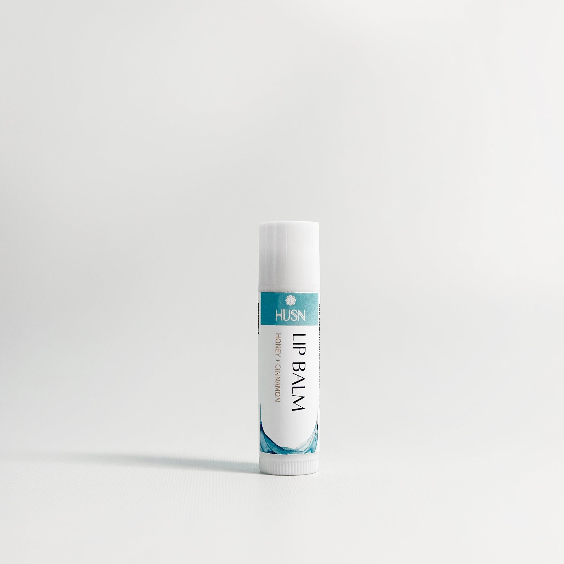 Lip balm tube with visible brand name on a white background